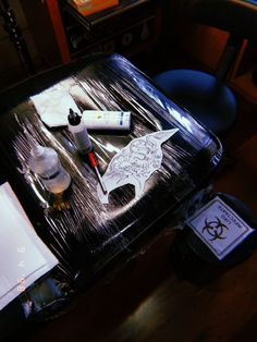 the table is covered with various items such as markers, pens and ink bottles on it