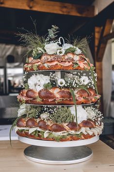 a tiered cake with meats and vegetables on the top is sitting on a table