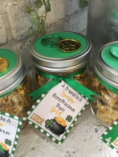 four jars filled with gold coins sitting next to each other on top of a table