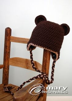 a crocheted bear hat sitting on top of a wooden chair