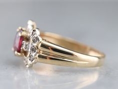 This vintage yellow and white gold ring dates to the late 1950s and has a sweet style and shape. Set with a deep red ruby this is a gorgeous gemstone expertly cut to show off the depths of its ruby red color. Accented by a ribbon of sparkling diamonds this sweet little stylized bow ring is ready to wear or gift to your sweetheart! Metal: 14K Yellow and White Gold Gem: Ruby .50 Carats Gem Measurements: 5.5 x 4.3 mm, Oval Accents: 16 Diamonds totaling .26 Carats, K in Color, I1 in Clarity Ring Siz Anniversary Red Cluster Ring Stamped 14k, Vintage Ruby Rings With Diamond Accents, Vintage Yellow Gold Ruby Ring, Heirloom Marquise Cut Red Ruby Ring, Vintage Ruby Ring With Diamond Accents, Vintage Ruby Jewelry With Diamond Accents, Vintage Ruby Ring With Diamonds For Formal Occasions, Vintage Ruby Cluster Ring For Formal Occasions, Vintage 14k Stamped Ruby Promise Ring