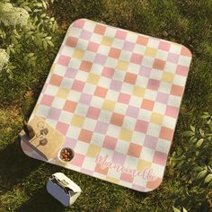 a picnic blanket with the word mamamie on it next to an empty lunch box