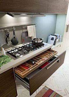 a stove top oven sitting inside of a kitchen next to a counter topped with pots and pans