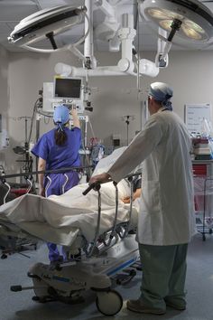 two doctors in scrubs are preparing to perform surgery