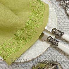 a plate with silverware on top of it next to a napkin and spoons