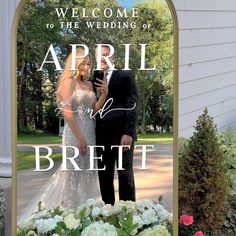 a bride and groom are standing in front of a welcome sign for their wedding day