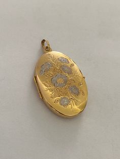 Large Gold Locket Beautiful two tone flower motif Flowers in white gold  Height including loop is approx 42mm Width approx 23mm Satin finish on back Weighs approx 4.7grams Hallmarked 9ct gold on soldered loop In good condition for secondhand item Gold Oval Jewelry With Flower Charm, Gold Hallmarked Flower-shaped Jewelry, Gold Flower Heirloom Jewelry, Heirloom Gold Flower Jewelry, Heirloom Flower-shaped Gold Jewelry, Antique Gold Jewelry With Flower Charm, Antique Gold Flower Jewelry, Formal Engraved Flower Jewelry, Formal Flower-shaped Engraved Jewelry