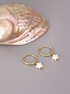 "Tiny Star hoop earrings. Handmade Mother of Pearl huggie Earrings.   Dainty Iridescent mother of pearl stars are set in your choice of 14k gold fill or sterling silver and hang 14mm endless hoops. Mother of Pearl stars are 6x6mm (about 1/4\" long).  Simple, elegant earrings perfect summer or beach wedding earrings for bridesmaids.  PLEASE note measurements and size reference pictures. Our jewelry and hair accessories are photographed close up to show detail and may appear larger than they are. White 14k Gold Filled Huggie Earrings, Dainty White 14k Gold Filled Huggie Earrings, Small Hoop White Huggie Earrings In 14k Gold, White Starfish Charm Earrings For Gift, Handmade Dainty White Huggie Earrings, Handmade White Dainty Huggie Earrings, White Starfish Charm Earrings As Gift, Dainty Handmade White Huggie Earrings, White Starfish Charm Earrings