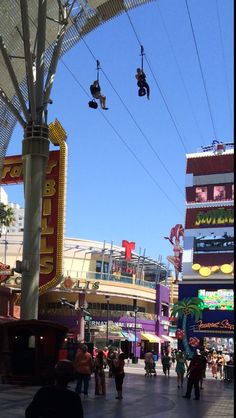 people are walking down the street in an amusement park