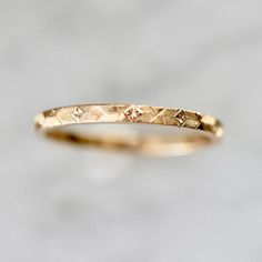 a gold wedding band with small diamonds on it