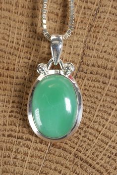 Chrysoprase Pendant Approx. Dimensions: 24x16x8 mm This pendant is made with .925 Sterling Silver. Chain is not included. Chrysoprase is a type of chalcedony, which is a variety of microcrystalline quartz, known for its distinctive apple-green color. It is considered a gemstone due to its attractive appearance and is often used in jewelry and ornamental objects. The green color of chrysoprase is attributed to the presence of nickel impurities within the mineral.Chrysoprase can vary in color inte Green Chrysoprase Oval Pendant Jewelry, Oval Jade Cabochon Necklace, Oval Jade Cabochon Necklaces, Chrysoprase Oval Pendant Necklace As Gift, Jade Cabochon Oval Pendant Necklace, Oval Chrysoprase Gemstone Necklace, Oval Chrysoprase Gemstone Necklaces, Chrysoprase Round Pendant Necklace As Gift, Chrysoprase Round Pendant Necklace For Gift