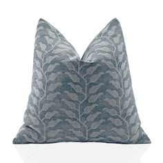 a gray and white pillow on a white surface