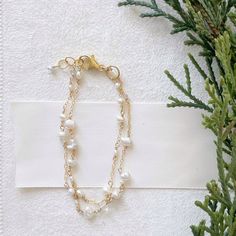 "Poppy Linen Bracelet" is perfect for our pearl lovers out there. Dainty and simple yet makes a beautiful statement. Pair it with a classic Caroline bangle for an elevated look. - Two strands of dainty white pearls in various shapes and sizes are accented by small chain. Small, faceted crystal quartz add a hint of shimmer. - adjustable, 6.75-7.25 inches - Available in 14K gold filled and sterling silver, for more information on our metals click HERE!