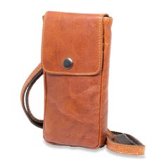 FREE MONOGRAMMING! HAND-STAINED BUFFALO LEATHER Make shopping, running errands, or traveling completely hands-free with this functional mini crossbody bag. The Voyager Phone Holder Crossbody is made from hand-stained Buffalo leather that builds a rich, deep patina as it ages. The front has card slots beneath a flap with snap closure. On the backside, an open pocket can hold your keys and other essentials. An adjustable shoulder strap allows you to wear it on your shoulder or across your chest. T Classic Soft Leather Phone Bag For Travel, Leather Mobile Phone Pouch For On-the-go, Cognac Travel Bag For Mobile Phone, Casual Soft Leather Phone Bag For Travel, Leather Travel Pouch With Adjustable Strap, Leather Crossbody Phone Bag For Travel, Travel Phone Bag In Soft Leather, Leather Mobile Phone Bag Pouch For On-the-go, Leather Phone Pouch For On-the-go