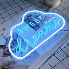 there is a neon sign that says sweet dreams on the side of a wall next to a tiled floor