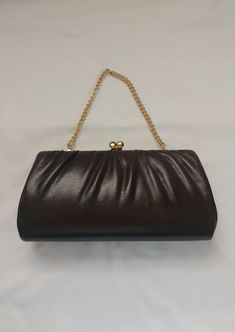 "This elegant 1970s/1980s Brown Purse is the perfect vintage accessory to finish your evening look! This deep brown leather purse has a retro charm with gold tone metal accents. The chain handle can be tucked inside, which turns the purse into a clutch. This classy purse is great for a gift or to accessorize for a special occasion! Purse measures 9\" wide x 5\" across x 1 1/2\" thick laid flat, 5\" chain pulled taught * Light rusting on the metal, light wear on the stitching, nice condition over Elegant Brown Evening Bag With Gold-tone Hardware, Vintage Brown Evening Bag For Party, Chic Brown Evening Bag With Chain Strap, Classic Brown Evening Bag For Formal Occasions, Elegant Brown Leather Evening Bag, Classic Brown Formal Evening Bag, Elegant Brown Evening Bag, Brown Evening Bag For Events, Chic Brown Evening Bag For Formal Occasions