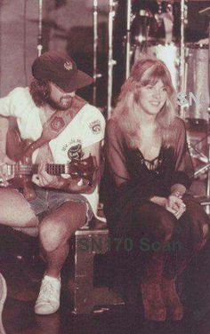 a man and woman sitting next to each other playing guitars