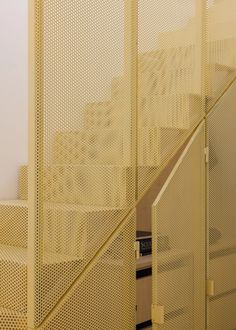 the stairs are covered with yellow mesh and there is a clock on each handrail