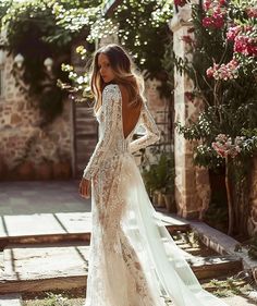 a woman in a wedding dress is standing on the steps and looking at her back