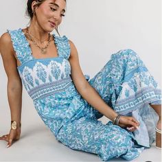 Get Ready To Turn Heads In This Stunning Jumpsuit! Featuring A Trendy Square Neckline And A Smocked Bodice, This Light Blue Boho Print Piece Is Perfect For Any Occasion. The Wide Shoulder Straps And Ruffle Detailing Add The Perfect Touch Of Femininity To This Breezy, Wide-Leg Jumpsuit. Square Neckline Wide Shoulder Straps Smocked Bodice Wide Ruffle Jumpsuit Light Blue Boho Print 100% Polyester Small - Bust: 26”, Waist: 26”, Hip: 38”, Inseam: 26.5” Blue Sleeveless Jumpsuit With Smocked Back, Sleeveless Blue Jumpsuit With Smocked Back, Bohemian Sleeveless Jumpsuit With Smocked Bodice, Bohemian Sleeveless Jumpsuits And Rompers With Smocked Bodice, Light Blue Sleeveless Romper For Vacation, Bohemian Jumpsuits And Rompers With Smocked Bodice For Vacation, Bohemian Jumpsuits And Rompers With Smocked Bodice, Blue Jumpsuits And Rompers With Smocked Back For Beach, Blue Vacation Jumpsuits And Rompers With Smocked Bodice