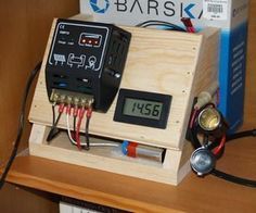 an electronic device is sitting on top of a wooden box with wires attached to it