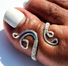 Silver toe rings are a great accessory. Toe rings are believed to exert pressure on certain nerves that enhance fertility and promote overall well-being. They are also a symbol of marriage in many Indian cultures. Toe rings are typically worn on the second toe, but can also be worn on the big toe, third, fourth, or pinky toe. The toe ring in this picture is worn on the left big toe. Please note this toe ring is suggested to be worn on the Big Toe. Toe rings sizes are typically 1-7. The most average toe sizes for women are 3-5; men most common wear 5-6 Handmade Material: Silver jewelry wire.  Tarnish resistant.  Nickel Free Made to Order Adjustable Nickel-free Toe Rings, Adjustable White Toe Rings, Nickel Free Spiritual Toe Rings, Spiritual Nickel-free Toe Rings, Nickel Free White Toe Ring, Handmade Adjustable Toe Rings For Anniversary, Nickel-free Open Toe Ring For Anniversary, Adjustable Open Toe Rings For Anniversary, Rings Indian