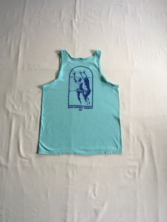 "vintage 1990s tank top shirt Hanes Beefy T 100% cotton, made in USA single stitch sea foam green w/image on back- front of shirt is blank back- print of 2 men playing volleyball (1 on each side of net w/ball in air) writing- Beva Summer Doubles 1991 good vintage condition, light wear-light stain- see photos label size L, see below measures, lying flat, shoulder-12\" chest-20\" length-28\"" Green 90s Style T-shirt For Summer, 90s Sports T-shirt For Summer, Pre-shrunk Cotton Sleeveless T-shirt, Cotton Racerback Muscle Tee For Summer, Casual Racerback Muscle Tee For Summer, Spring Cotton Racerback Muscle Tee, Summer Gym Cotton Top, Summer Cotton Gym Top, Cotton Gym Top For Summer