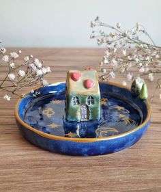 a blue and yellow bowl with a small house on it