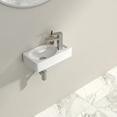 a white sink sitting next to a wall mounted faucet