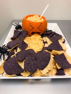 a white plate topped with tortilla chips and a jack - o'- lantern