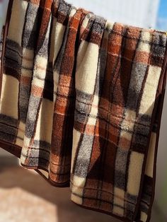 a brown and white checkered blanket hanging from a clothes line