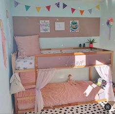 a child's bedroom with two bunk beds and pink sheets on the bottom bed