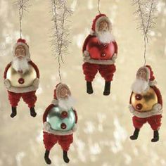 santa claus ornaments hanging from branches in the snow