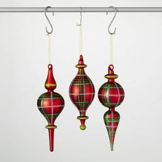 three red and green ornaments hanging from hooks