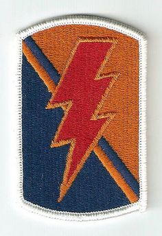 an embroidered patch with a red and blue lightning bolt on the center, in front of a white background