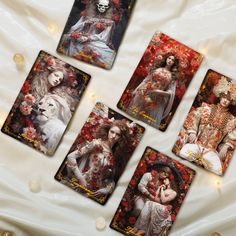 four tarot cards with images of women and cats on them, all surrounded by red flowers