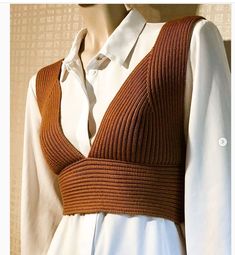 a woman's white shirt and brown sweater on a mannequin