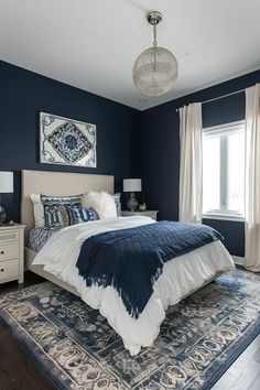 a bedroom with dark blue walls and white bedding, rugs on the floor