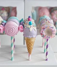 three ice cream cones with sprinkles and candies on them