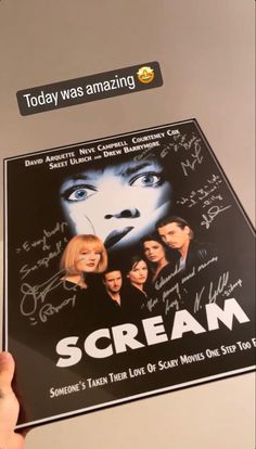 someone holding up a movie poster with the words scream on it and some autographs