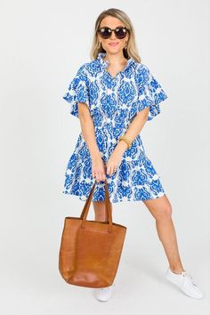 This printed dress features a smocked waistband, a ruffled collar, and A-line skirt. The blue and white print is both timeless and right on-trend! Ruffles on the collar, skirt, and sleeves give it an extra sweet look! Casual Tiered Dress With Smocked Cuffs, Casual Cotton Dress With Ruffled Collar, Casual Smocked Dress With Ruffle Sleeves, Casual Smocked Dress With Ruffle Hem And Sleeves, Blue Tiered Smocked Dress With Ruffle Hem, Casual Smocked Dress With Ruffle Sleeves For Daywear, Casual Blue Smocked Dress With Ruffles, Blue Spring Dress With Ruffled Collar, Blue Casual Cotton Smocked Dress