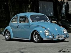 a blue vw bug is parked on the street