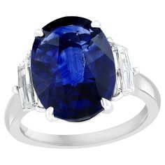 an oval blue sapphire and diamond ring with baguets on the shoulders, set in white gold