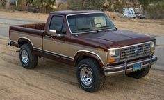 a brown pick up truck parked on the side of a road