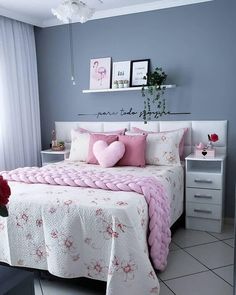 a white and pink bedroom with flowers on the bed