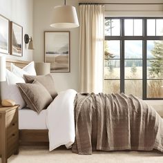 a bedroom with a bed, dresser and window in the corner that has pictures on the wall above it