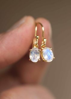 Our Moonstone Dangle Earrings in 18k gold vermeil are just the right size to be noticed and small enough to wear all day comfortably. The stone is a large 7mm x 5mm natural blue flash genuine oval Moonstone, set in a sturdy prong setting. A classic with a touch of modern, also available in sterling silver. Sold as a pair, comes with extra silicone ear backs to keep them secure.DETAILS• Dimensions: Stone - 7mm x 5mm, total length - 22mm• Weight - 0.7 g• Material - 925 sterling silver, 18k thick g Round Moonstone Earrings, Everyday Round Moonstone Earrings, Minimalist 14k Gold Earrings With Gemstone, Hypoallergenic Gold Moonstone Jewelry, White Moonstone Earrings For Daily Wear, Everyday Moonstone Gemstone Earrings, Everyday Gold Plated Gemstone Earrings, Delicate Hypoallergenic Moonstone Jewelry, Minimalist Hypoallergenic Moonstone Earrings