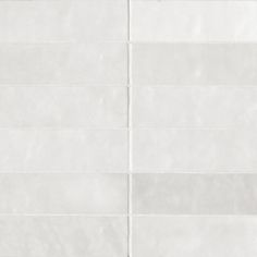 a white tile wall with vertical lines on it