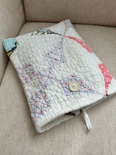 a white quilted pillow sitting on top of a couch