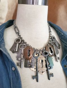 Repurposed Skeleton Key and Door Escutcheon Industrial Style Statement Necklace - Upcycled Door Hardware Necklace from Key of A Upcycled Jewelry There's something about vintage and antique hardware that is aesthetically pleasing to the eye.  The shapes, metal tones and not to mention the history that comes with each component.  What door did they open?  What doors were they part of and what stories they all could tell! This necklace features a random mix of beautifully aged door escutcheons.  They are mostly steel but each has a unique shape, patina and size.  One is painted a satiny black and there are two lovely matching bronze oval ones.  The cadillac of the bunch that I placed front and center is a vintage Eastlake style cast escutcheon that is simply stunning   The skeleton keys consi Things To Make With Old Jewelry, Old Key Crafts, Antique Key Necklace, Hardware Necklace, Homemade Jewellery, Skeleton Key Jewelry, Wolf Trap, Key Necklace Vintage, Upcycled Vintage Jewelry